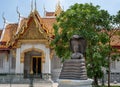 Bangkok, Thailand - February 04, 2023: Bronze buddha statue entwined with cobra