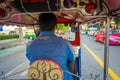 BANGKOK, THAILAND, FEBRUARY 08, 2018: Inside viuew of unidentified man driving a three-wheeled tuk tuk taxi in a road in Royalty Free Stock Photo