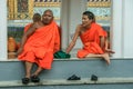 Group of Buddhist monks as tourists resting in the shadows on the territory of Grand Palace.