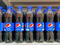 Many bottles of Pepsi Cola on the shelf for sale