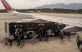 Bangkok, Thailand, 24 January 2024: Boarding process at airport, travelers leaving shuttle bus, moving towards airplane ramp. Royalty Free Stock Photo