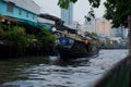 BANGKOK, THAILAND - January 11, 2019. Boat on a river in Bangkok downtown with local huts and skyscrapers on background