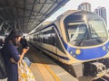 Passengers are waiting the arrival of the airport rail link sky train. People wait in an orderly line behind the yellow arrows poi Royalty Free Stock Photo