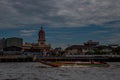 Long-tailed boat rushing on water surface against of Chao Phraya through the Santa Cruz Church in the Kingdom of Thailand