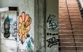 The old cement staircase and the graffiti patterns on cement wall is in the abandoned building and was left to deteriorate over