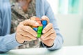 BANGKOK, THAILAND JULY 11 2023 Alzheimer disease AD, Asian elderly woman patient playing Rubik cube game to practice brain