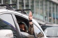 `Car Mob` Protesters a three finger salute to show symbolic gestures between driving vehicles and honk.