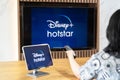 Disney+ Hotstar movie app logo on ipad and smart TV television screen sharing in home living room