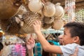 Bangkok, Thailand: a smiling boy excitedly touches a dried porcupinefish at Chatuchak Weekend Market