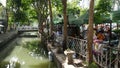 BANGKOK, THAILAND - 11 JULY, 2019: Street city life near river canal in siam. Traditional khlong with bridge near local market.