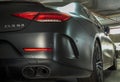 Close-up of Rear light or Tail lamp, exhaust pipe and Wheel of Matte black mercedes sports car parked in the parking lot