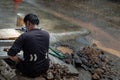 Utility worker using tool to fixing broken water main for commercial building water supplies during a rain Royalty Free Stock Photo