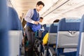 BANGKOK, THAILAND - June 27, 2019 - Bangkok Airways flight attendant serve drink to passengers on board.