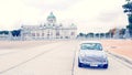 Blue classic Mini Austin parked on street with ancient castle and sky background in center of Bangkok, Thailand. Royalty Free Stock Photo