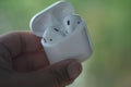 Bangkok, Thailand - June 9, 2020: Hands holding Airpods case in hand, Apple wearable earphones