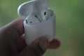 Bangkok, Thailand - June 10, 2020: Hands holding Airpods case in hand, Apple wearable earphones