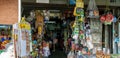 A young woman buying some consumer goods in old grocer`s street shop.