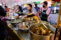 Bangkok, Thailand - June 23, 2020 : Unidentified vendor scoop food into plastic bag for customer