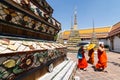 BANGKOK, THAILAND - MARCH 2019: buddhist monks walking along the giant stupas of Reclining Buddha Temple