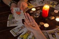 Bangkok,Thailand,March.15.20.The girl holds wedding rings on her hand with Tarot cards,crystals,a magic ball and a lighted candle.