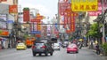 Hectic Yaowarat road filled with traffic and numerous signs attracting tourists.