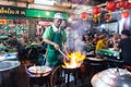 Bangkok, Thailand - March 2019: man cooking seafood at the Chinese night market street restaurant