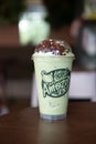 Bangkok, Thailand - March 22, 2020: Milk green tea frappe topping with red beans on wood table at Cafe Amazon are found in every