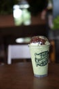 Bangkok, Thailand - March 22, 2020: Milk green tea frappe topping with red beans on wood table at Cafe Amazon are found in every