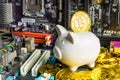 Bangkok, Thailand - March, 22, 2021 :Piggy bank and stack of Bitcoin coins on Computer motherboard .Concept of business and