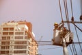 Electricians wiring and repairing wires, workers in buckets, attaching cranes, fixing high-voltage transmission lines.