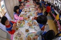 Primary school students eat lunch in the school canteen.