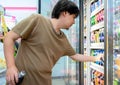 BANGKOK, THAILAND - MARCH 24: Unidentified man selects and purchases Pepsi Cola soft drink in 7-Eleven convenient store on