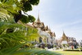 BANGKOK, THAILAND - MARCH 2019: View over Grand Palace and Chakri Maha Prasat hall through the trees and bushes