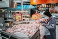 Bangkok, Thailand - May 18, 2020 : asian senior old woman wearing hygiene face mask choosing and shopping fresh chicken meat in Royalty Free Stock Photo