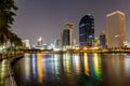 Bangkok, Thailand- May 1, 2017. Benjakitti public park in Bangkok city in the twilight with skyscrapers and lights reflecting in Royalty Free Stock Photo