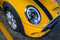 Close-up of Headlights, Wheel, and Rim of Yellow mini cooper Royalty Free Stock Photo