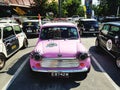 Cute pink mini Austin classic car parking on the road - Small and Vintage car concept