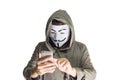 Bangkok, Thailand - May 6, 2018 : A hacker wears a mask wearing a robe. using smartphone theft and attacking data on cyberspace.