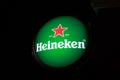 Heineken logo hang on the wall building on the dark or black background at night time.