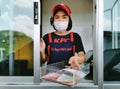 Bangkok, Thailand - May 7, 2020 : KFC fast food cashier in drive thru service waring hygiene face mask to protect coronavirus