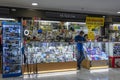 Man working in a electronics and cell phone store in shopping mall, Bangkok, Thailand . Young seller consultant stands behind the