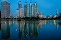 BANGKOK, THAILAND - 7 Nov 2019 :Reflection office building water front a Benjakiti green park Twilight