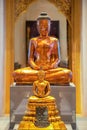 An ancient Buddha statue displayed in a hall at the Bangkok National Museum