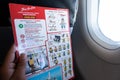 Bangkok, Thailand - November 20, 2018: Asian man read flight safety instructions on card board flight.