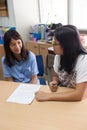 In a college in Bangkok, a school teacher corrected and helps a