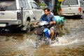 Bangkok, Thailand - November 5, 2011 : A delivery man drives a motorcycle on a flooded street after torrential rain