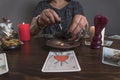 Fortune teller medium lays out Tarot cards and guesses for the future with wedding ring.