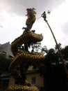 A man on a bamboo fights with a dragon on a pole suggested by several boys in a Festival of the Clans of the Chinese community in