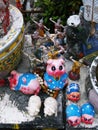 Small figures of dancers and pigs deposited as an offering at the Pig Memorial. Bangkok Pig Monument