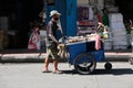 Street food vendor pushes his mobile cart